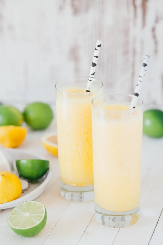 Bild von Limonade und hübschen Trinkhalmen mit Limetten