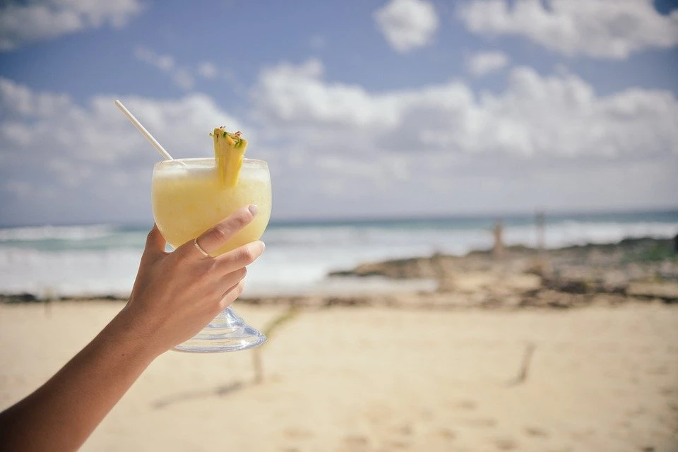 Eine Frau, die einen Pina Colada hält